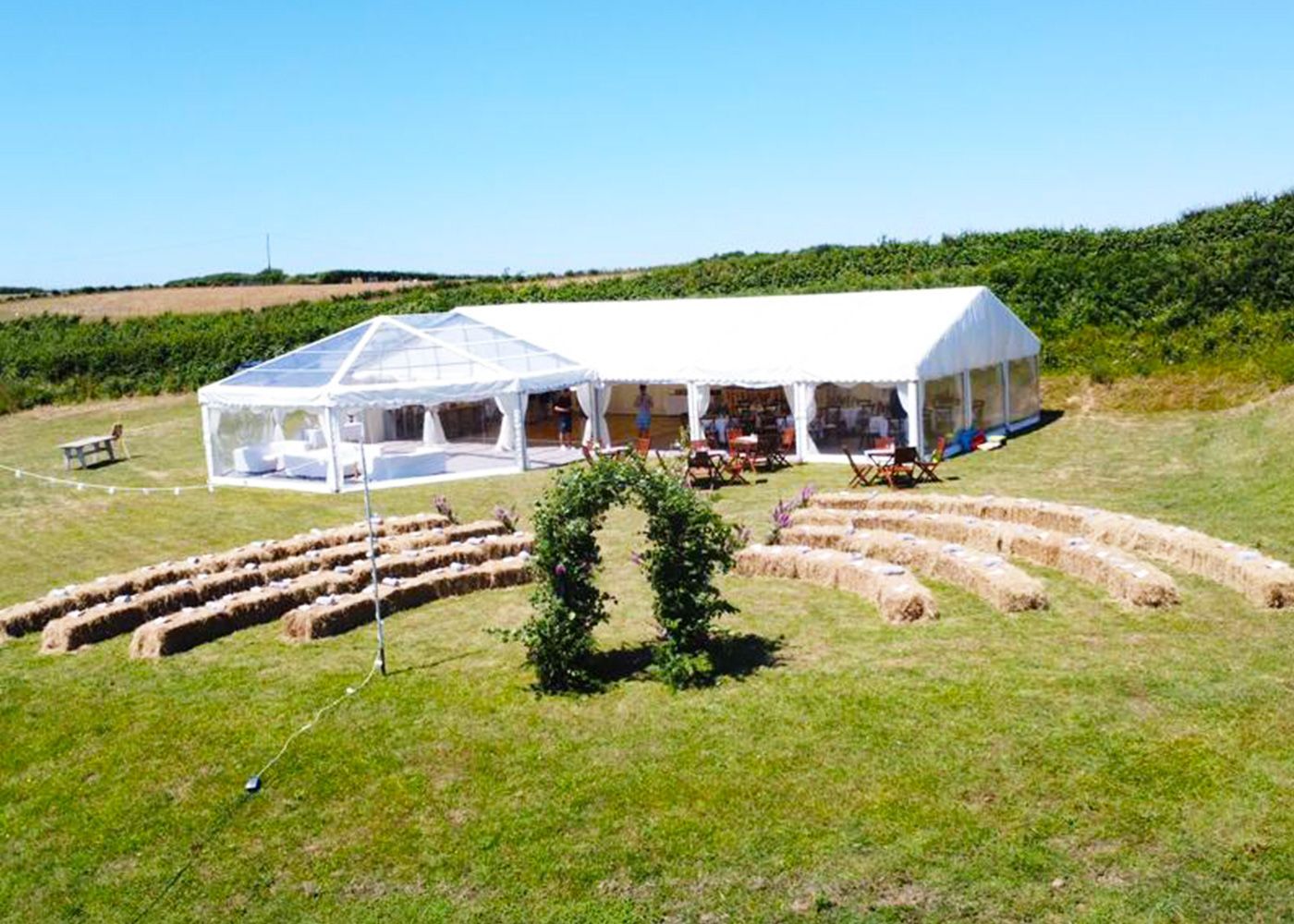 A large white tent is sitting in the middle of a grassy field.