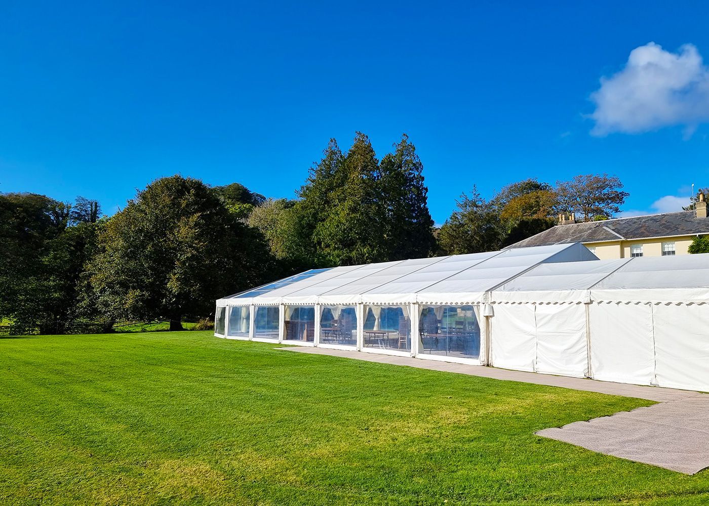 A large white tent is sitting in the middle of a grassy field.