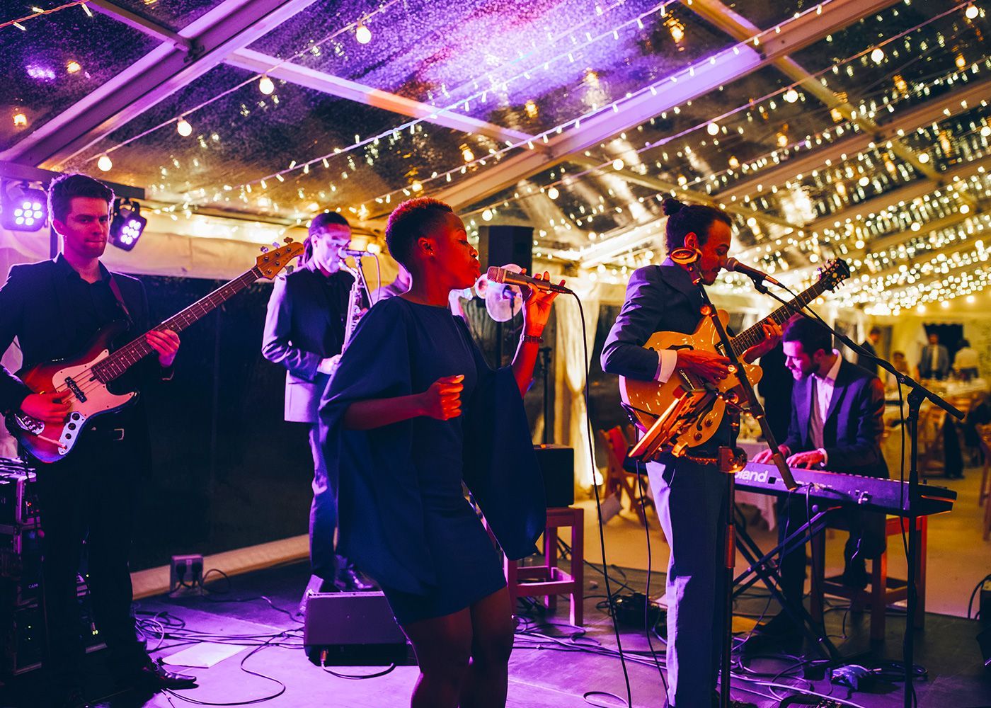A group of people are playing instruments and singing on a stage.