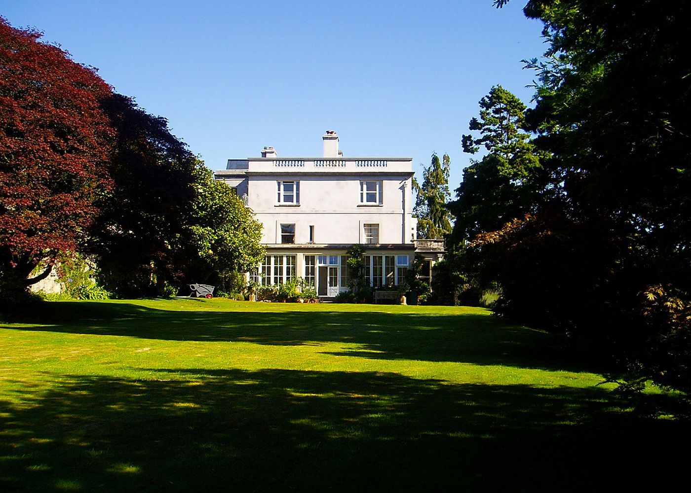 A large white house with a large lawn in front of it