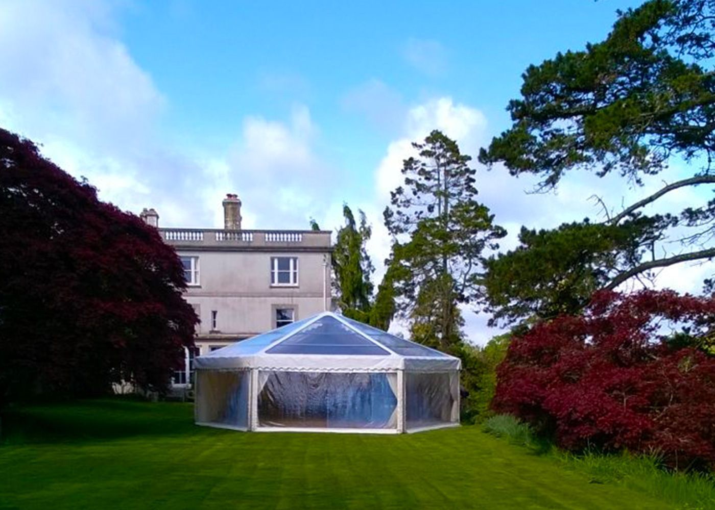 A large house with a clear tent in front of it