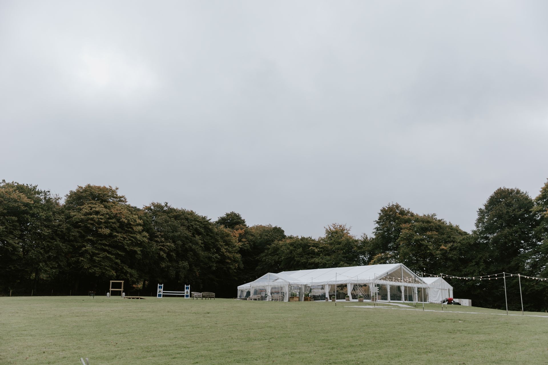 A large white tent is sitting in the middle of a grassy field.