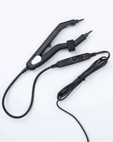 Black heat sealer with a temperature control dial, on a white surface.