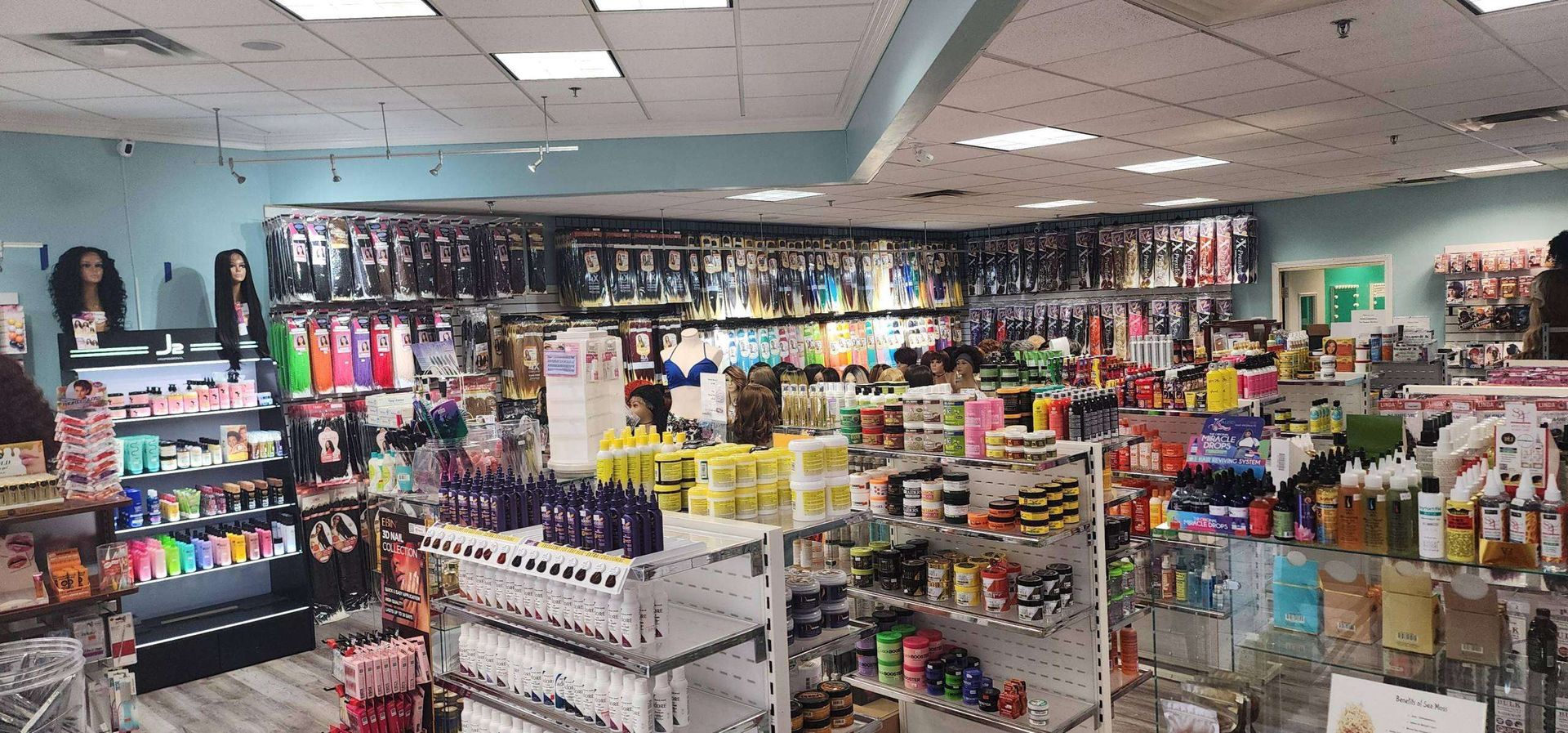 Interior of a beauty supply store with shelves stocked with hair products and wigs.