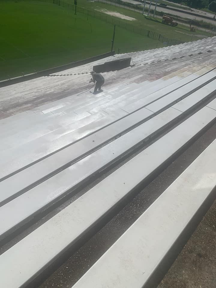 Person working on concrete surface with several parallel sections outdoors.