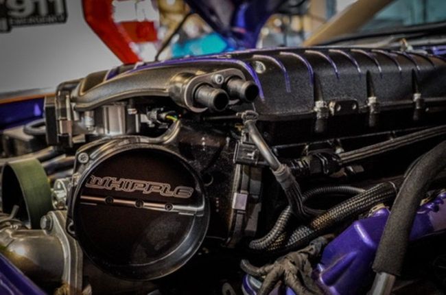 A close up of the engine of a purple car.