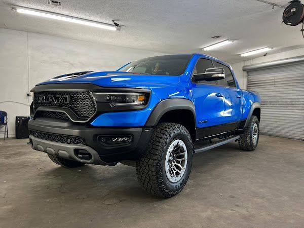 A blue ram truck is parked in a garage.