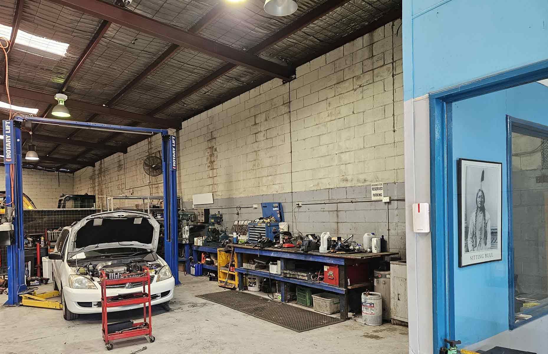 Car On A Lift In A Garage — Erina Car Air Conditioning In Wyoming, NSW