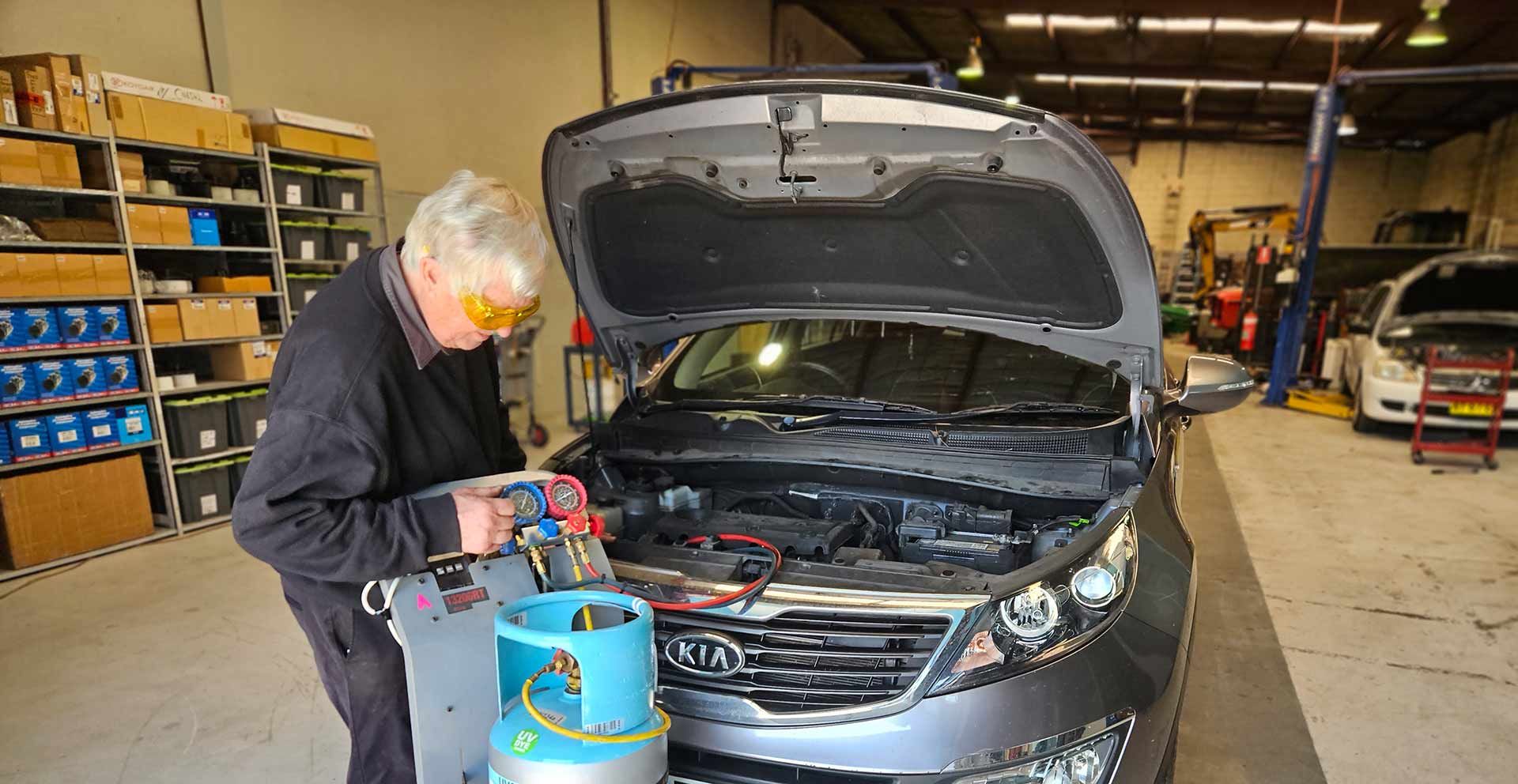 Man Working On A Car In A Garage With The Hood Open — Erina Car Air Conditioning In Erina, NSW