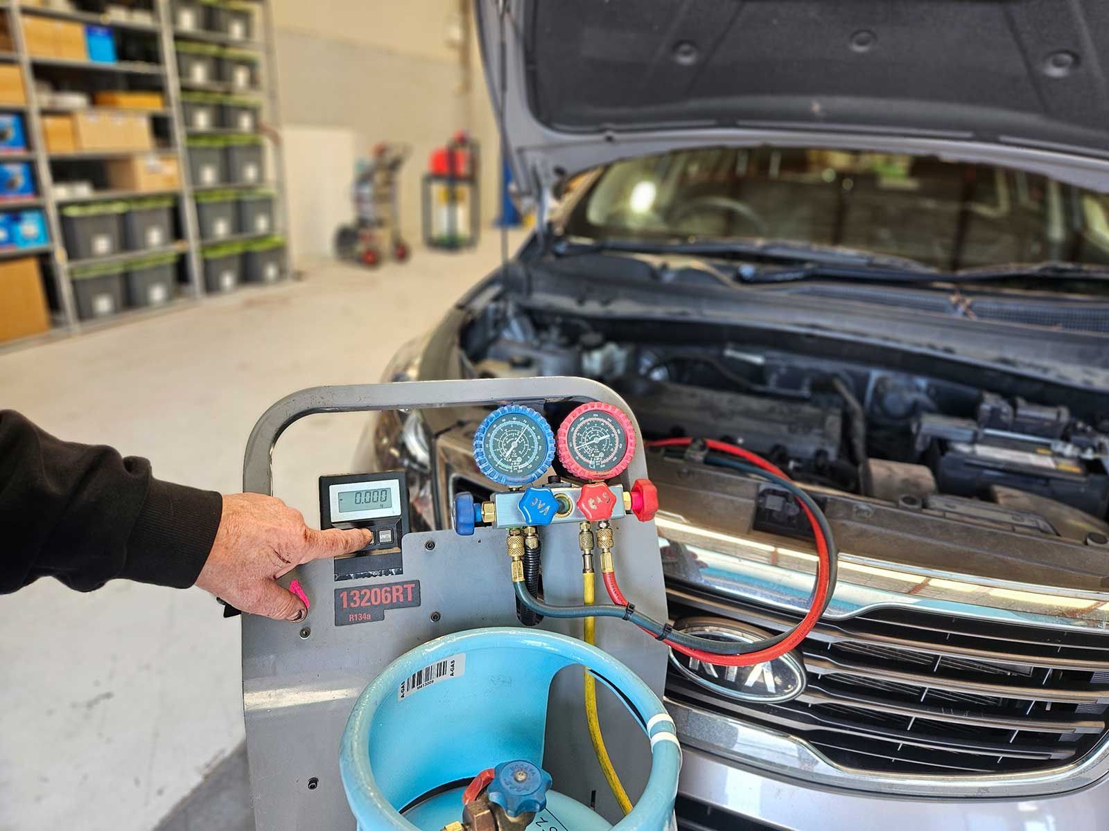 Person Re-gassing On A Car With The Hood Open In A Garage — Erina Car Air Conditioning In Gosford, NSW