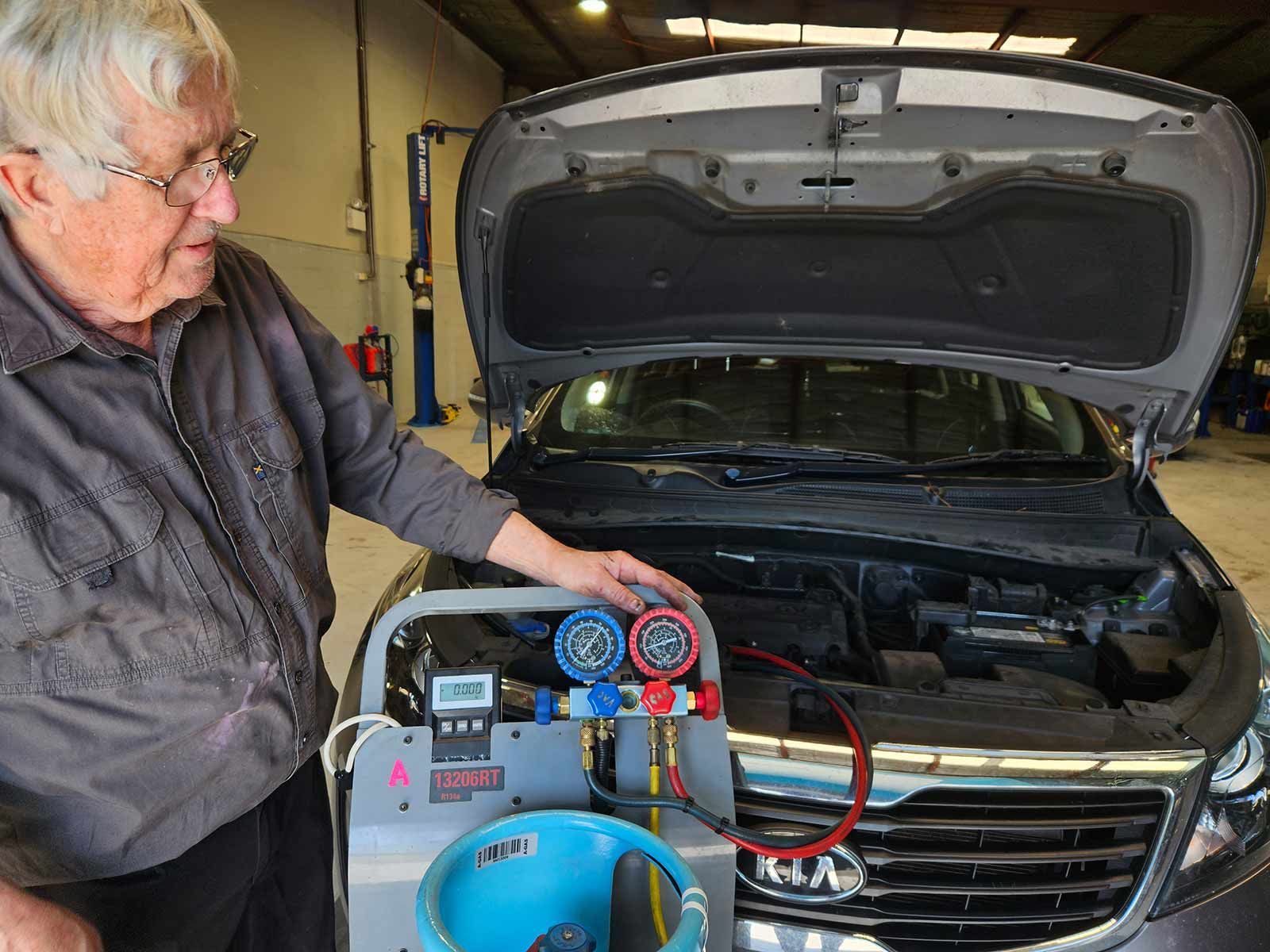 Man Diagnosing A Car Air Conditioning With The Hood Open — Erina Car Air Conditioning In Erina, NSW