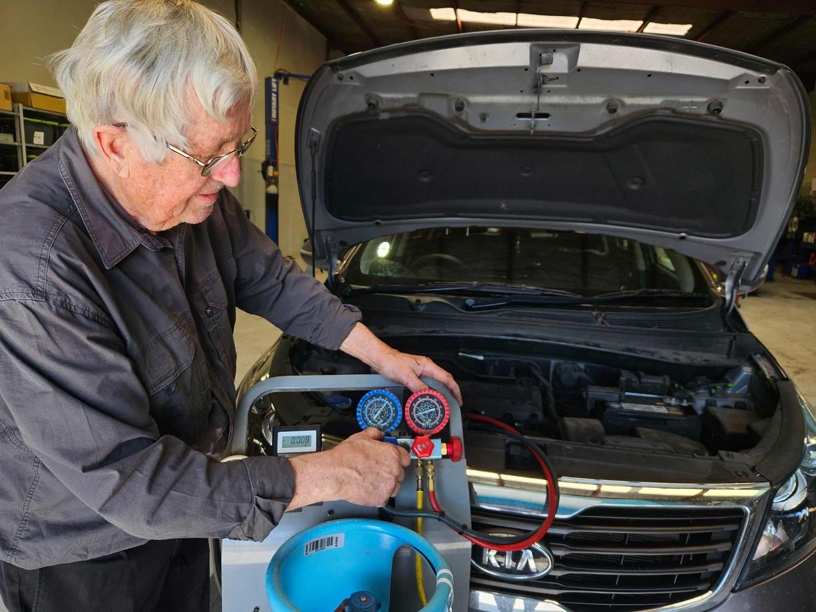 Man Working On A Car With The Hood Open In A Garage — Erina Car Air Conditioning In Erina, NSW