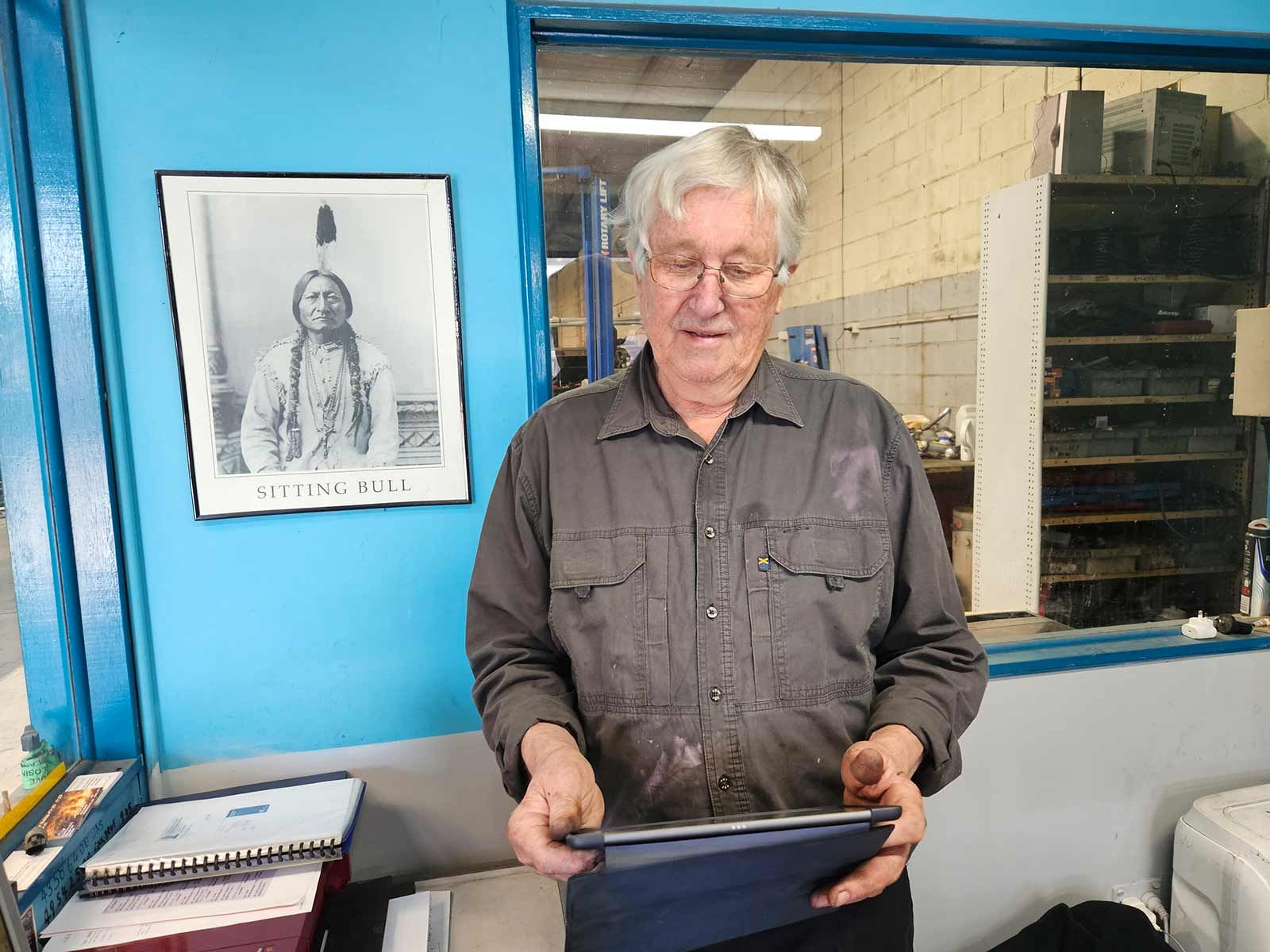 Man Standing In Front Of A Window Holding A Tablet — Erina Car Air Conditioning In Terrigal, NSW