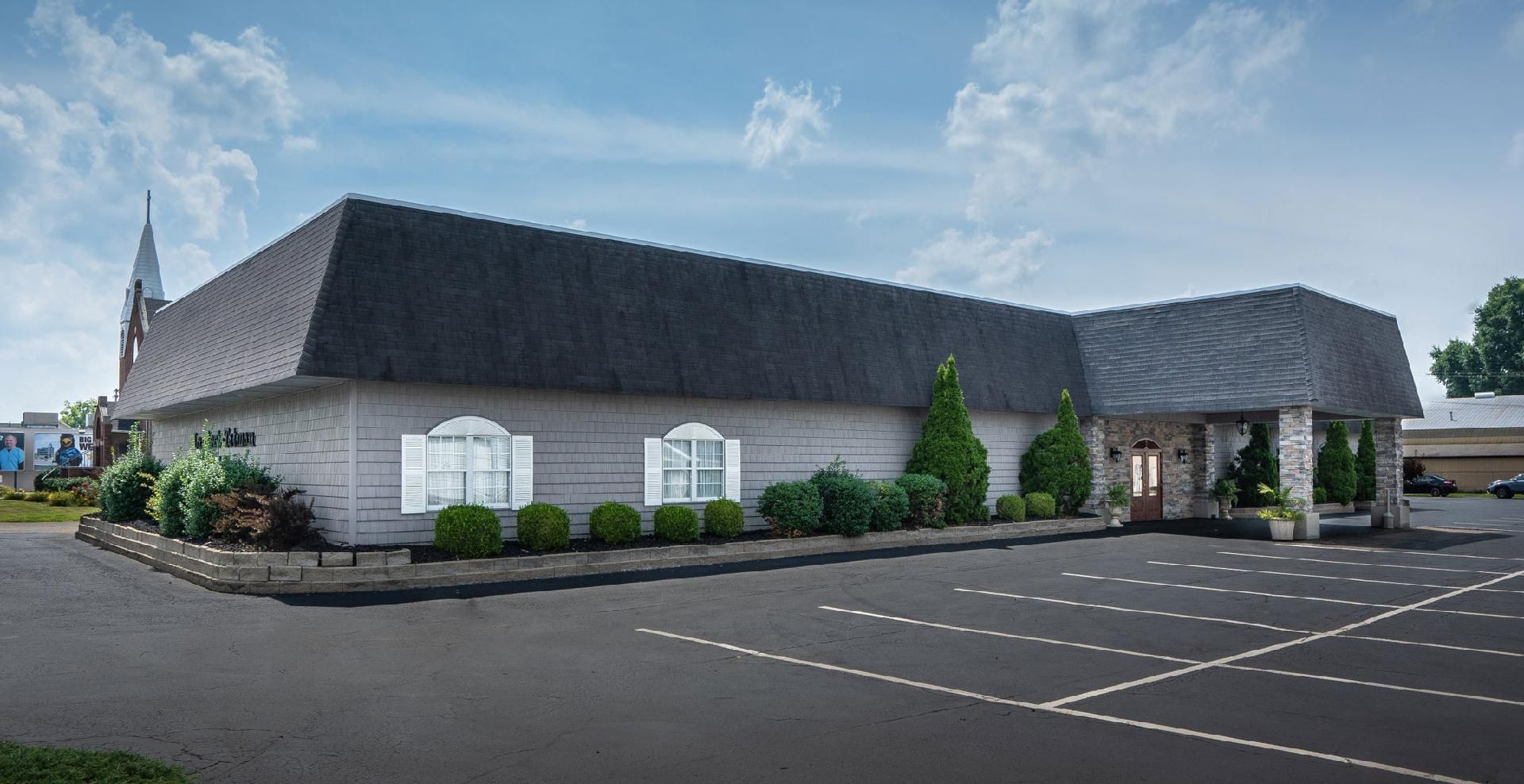 A large white building with a parking lot in front of it.