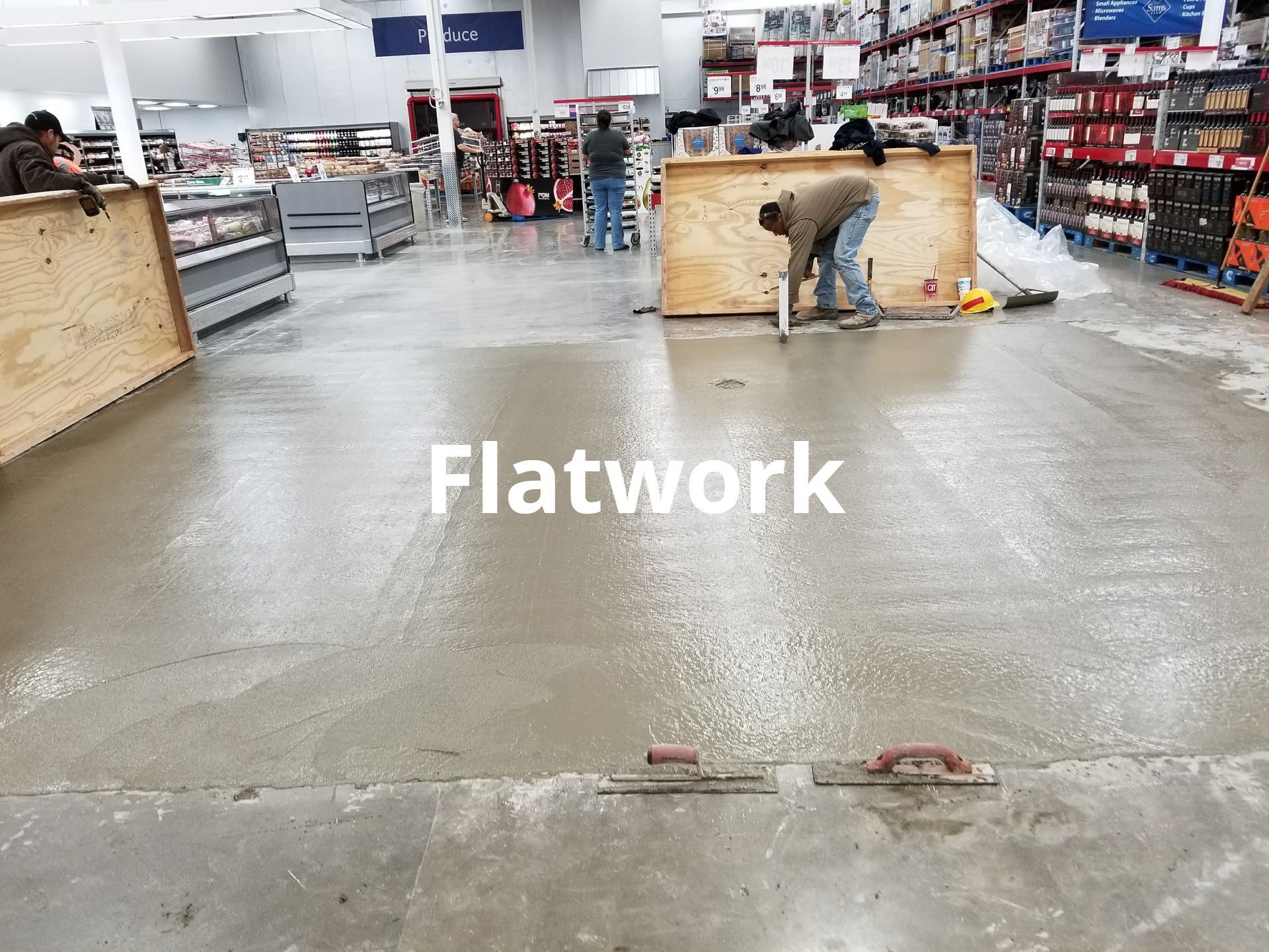 A man is working on a concrete floor in a store.