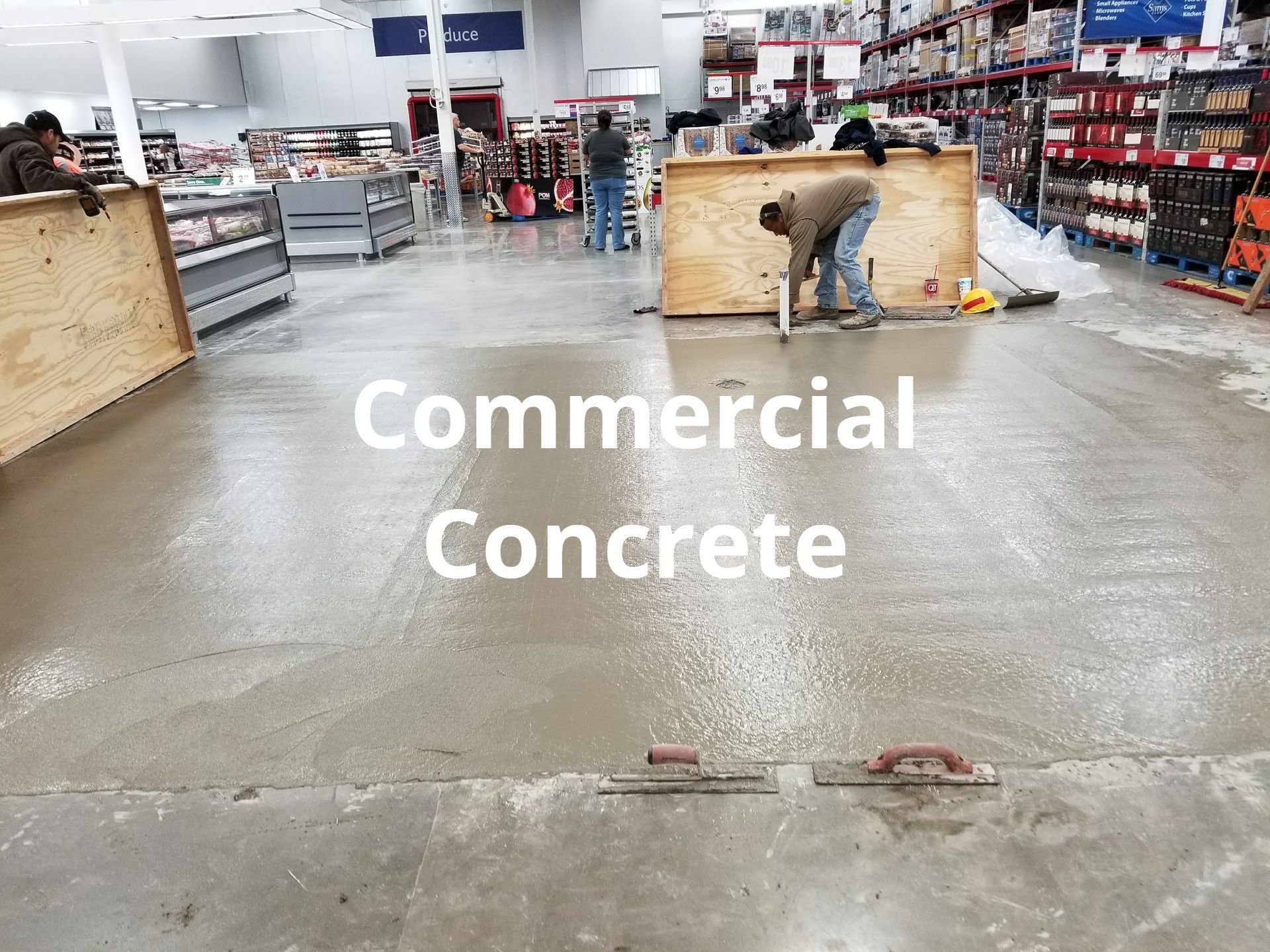 A man is working on a concrete floor in a store.