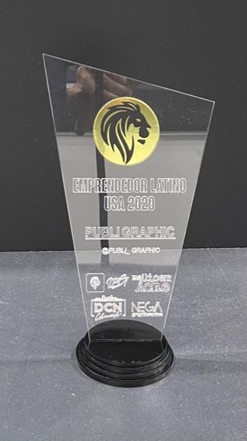 A clear trophy with a lion on it is sitting on a table.