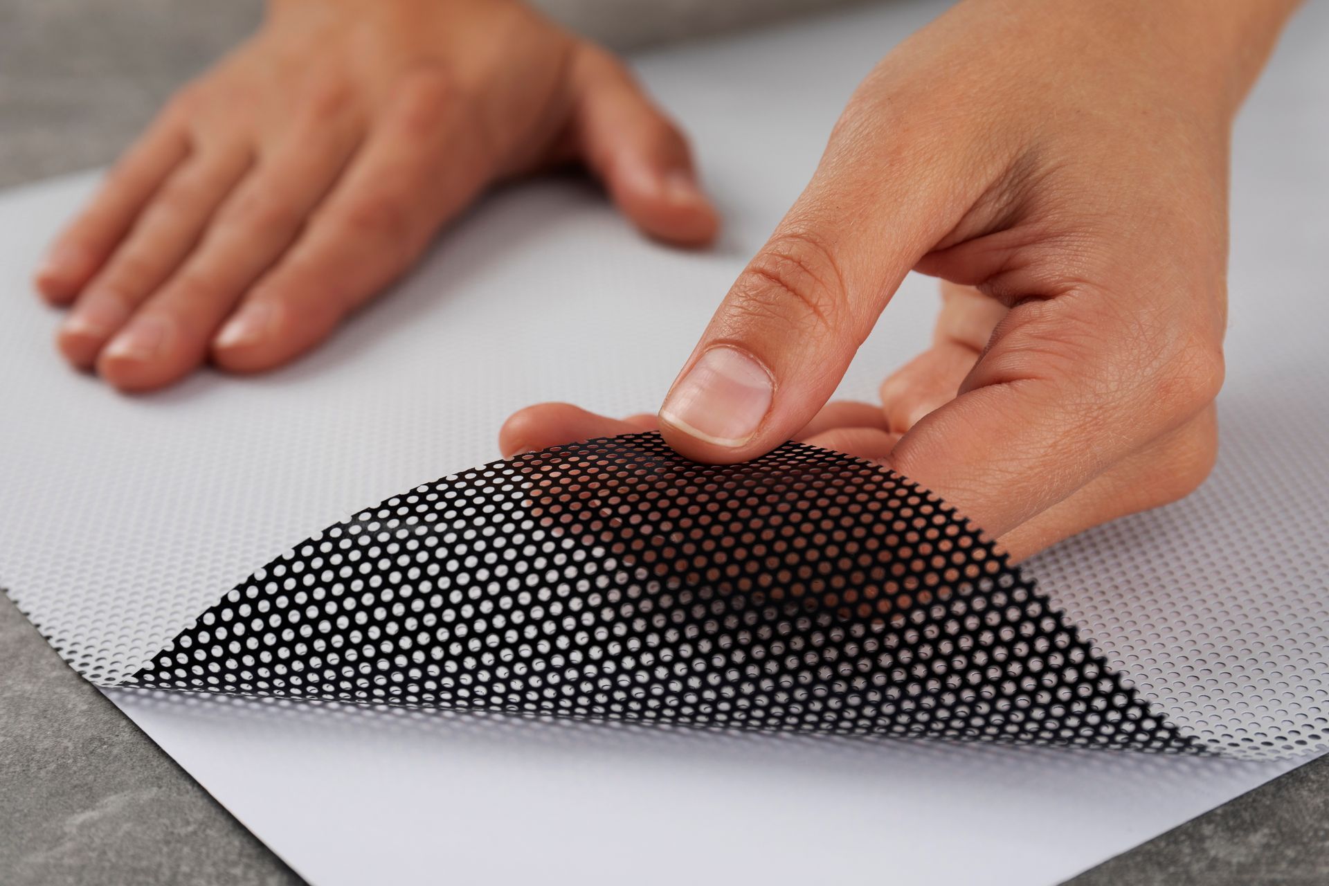A person is peeling off a piece of paper with their finger.