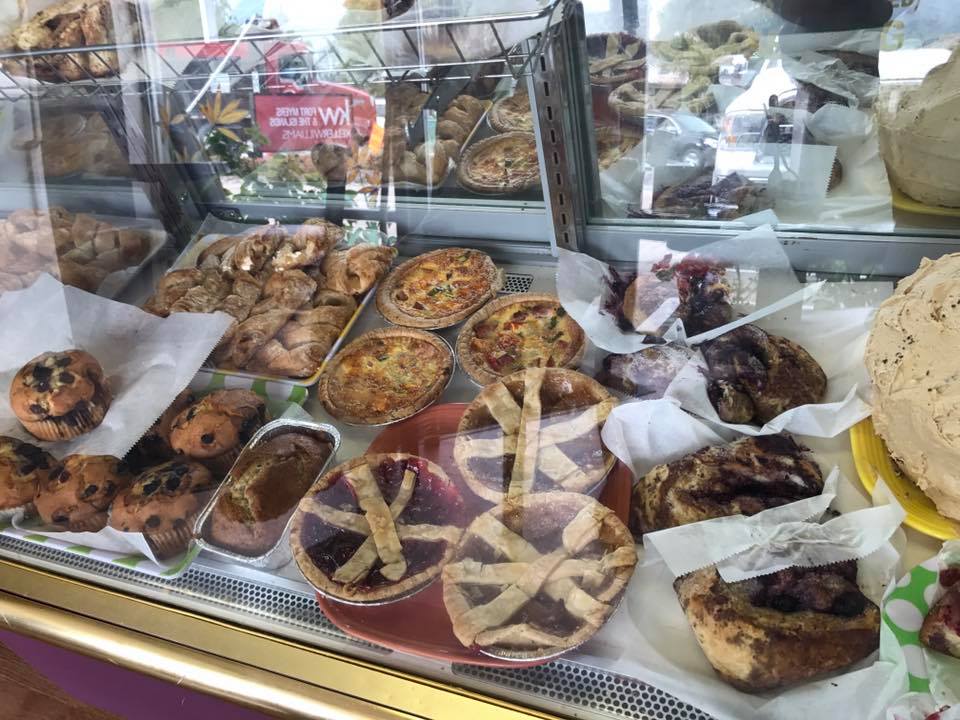 Pastries in a display case; various tarts, muffins, and rolls.