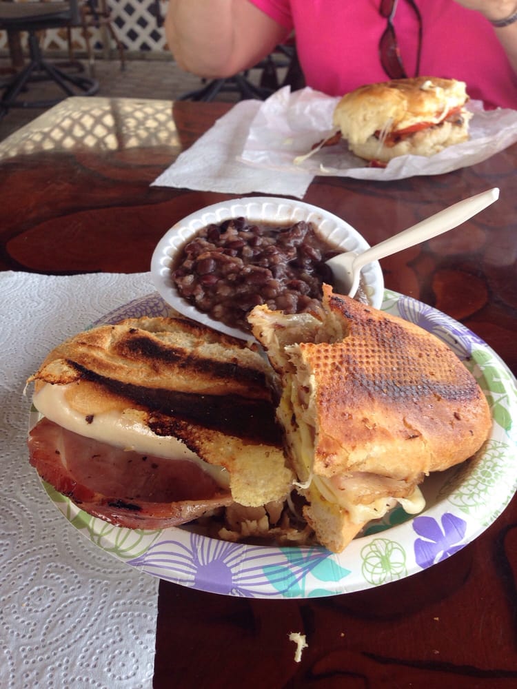 Grilled Cuban sandwich with black beans and another sandwich in the background.
