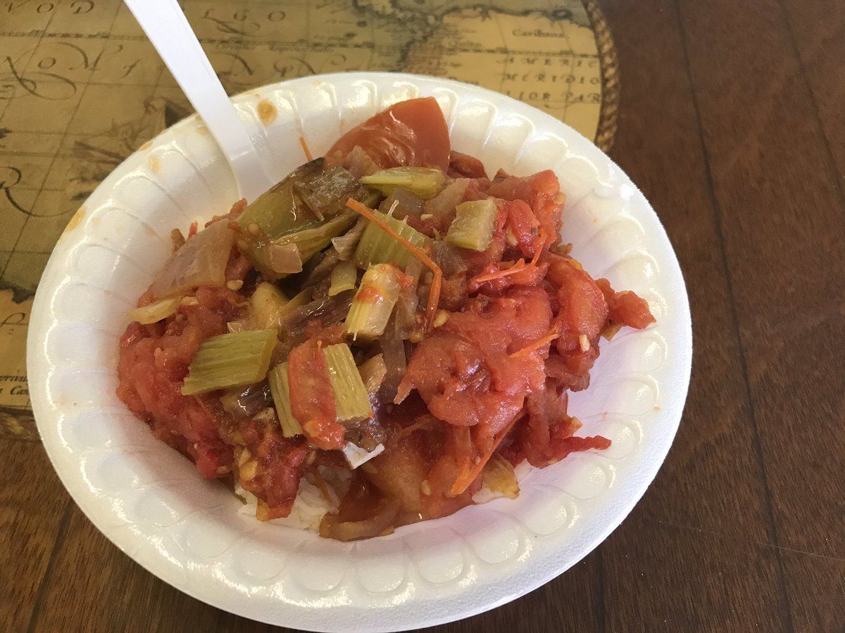 Tomato and celery dish in a white bowl with a white fork on a table.