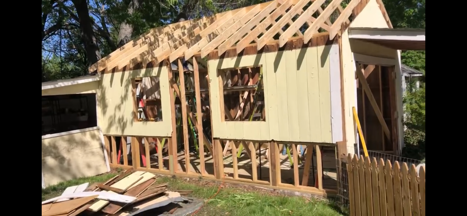 A house is being built with wooden beams and a roof.