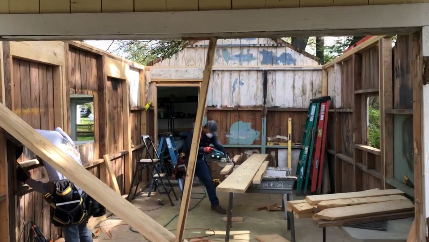 A group of people are working on a wooden building.