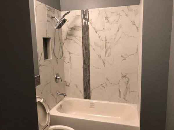 A bathroom with a tub , toilet and shower.