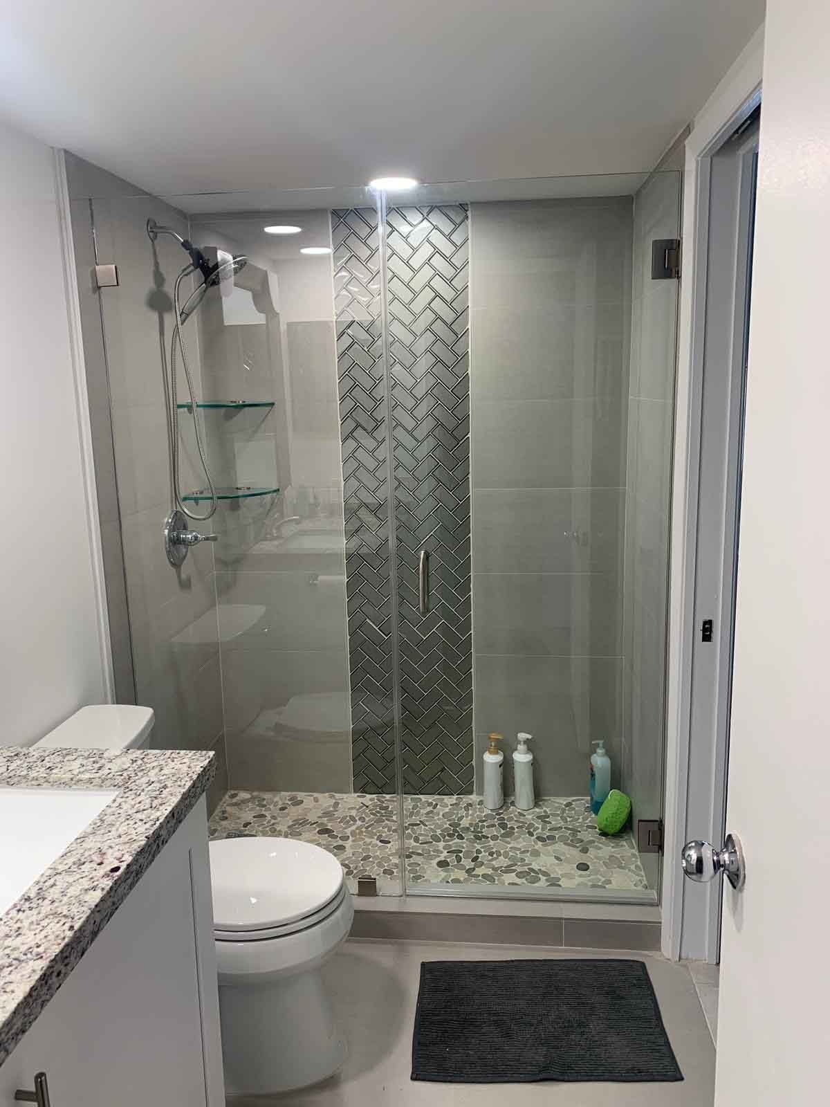 A bathroom with a toilet , sink , and walk in shower.