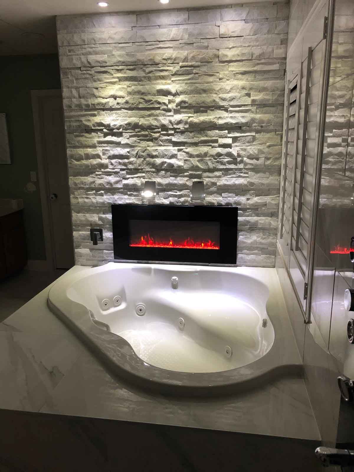 A bathroom with a jacuzzi tub and a fireplace.