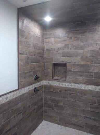 A bathroom with a walk in shower and a mirror.