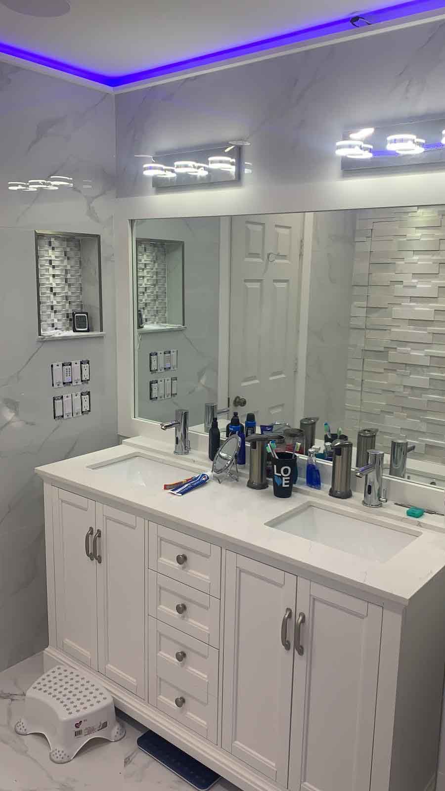 A bathroom with two sinks , a mirror and a step stool.