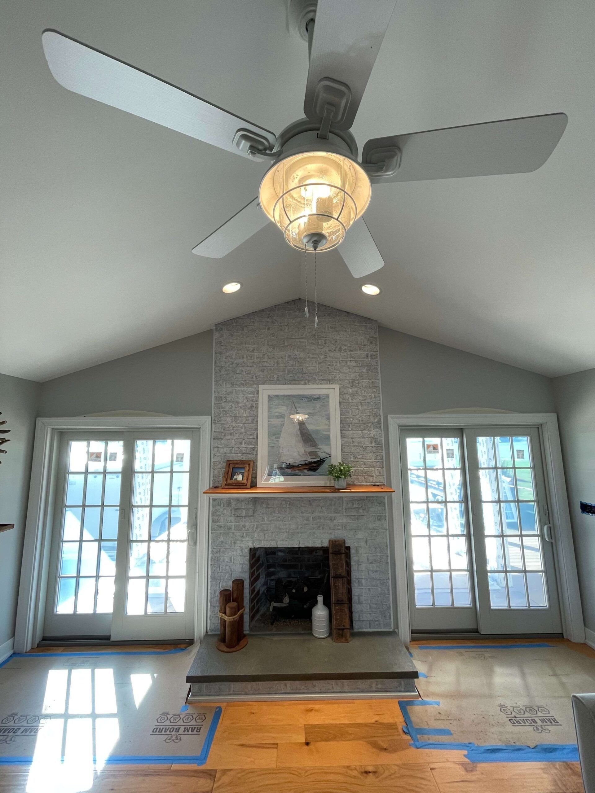 A living room with a fireplace and a ceiling fan