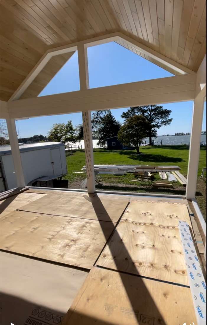 A room with a lot of windows and a wooden floor.