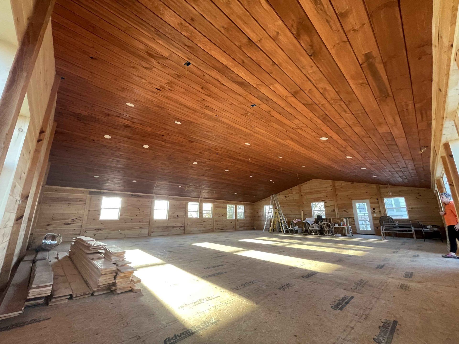 A large room with a wooden ceiling and a lot of windows.
