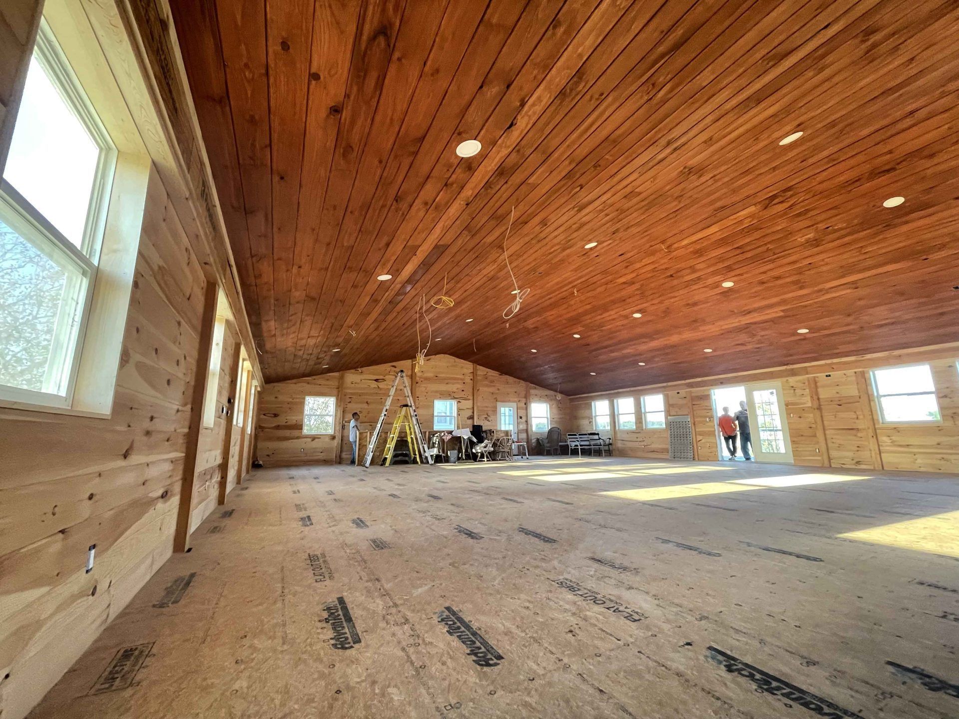 A large room with a wooden ceiling and a lot of windows.