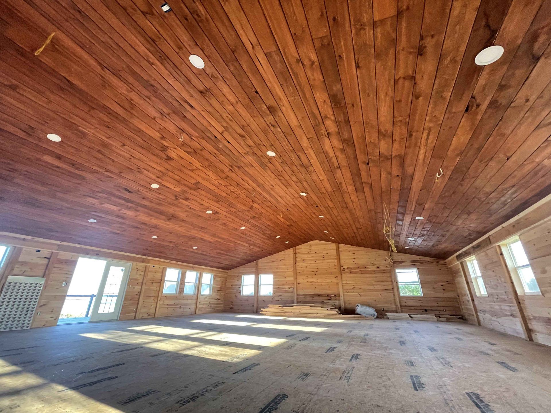 A large room with a wooden ceiling and a lot of windows.
