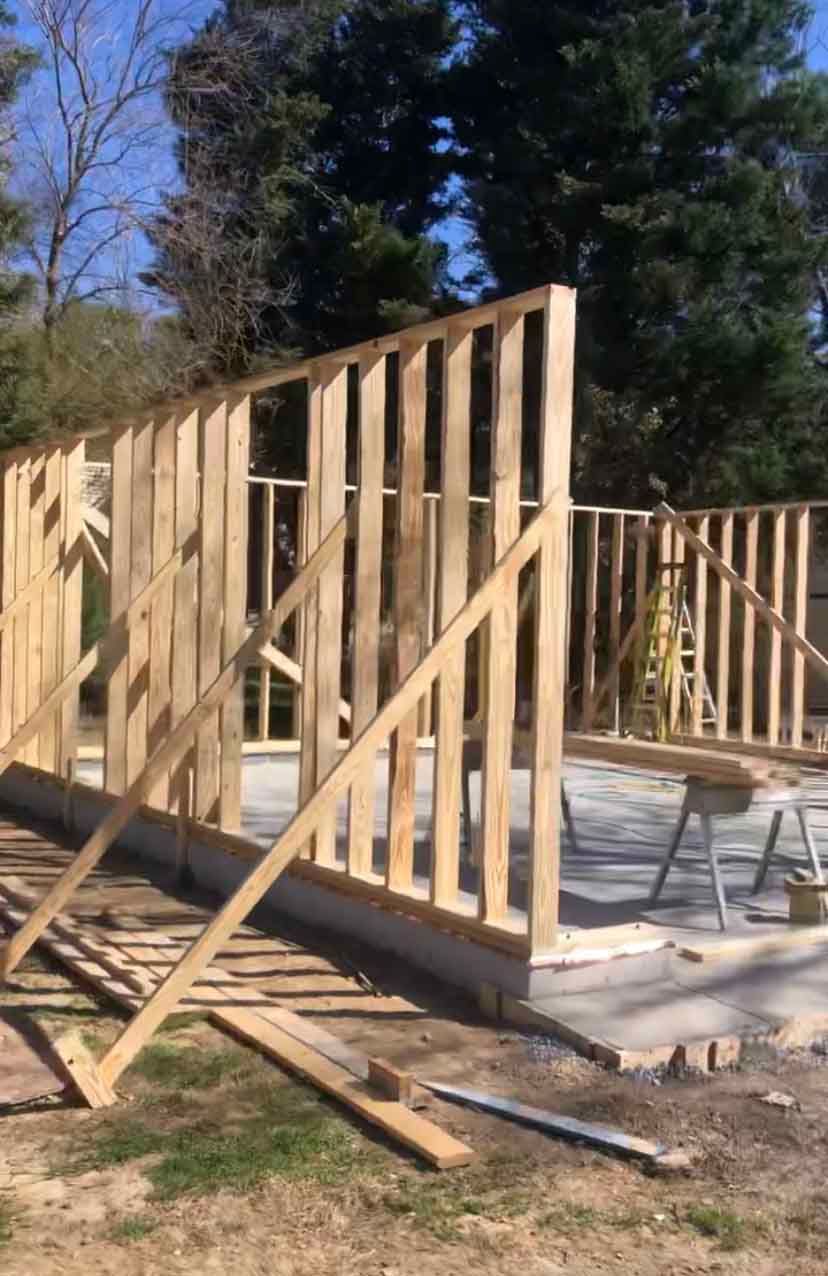 A wooden structure is being built in a yard.