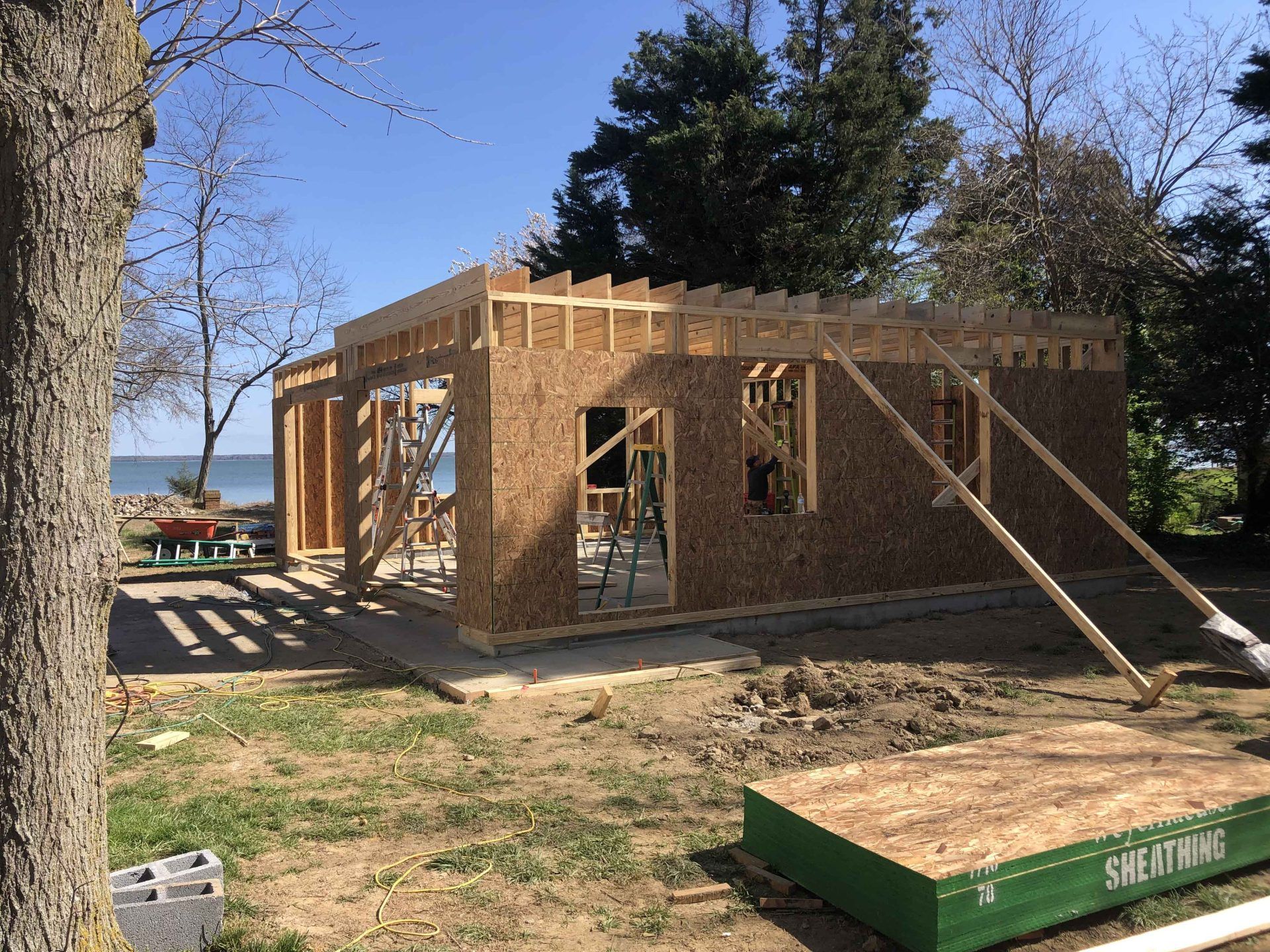 A house is being built on the shore of a lake.