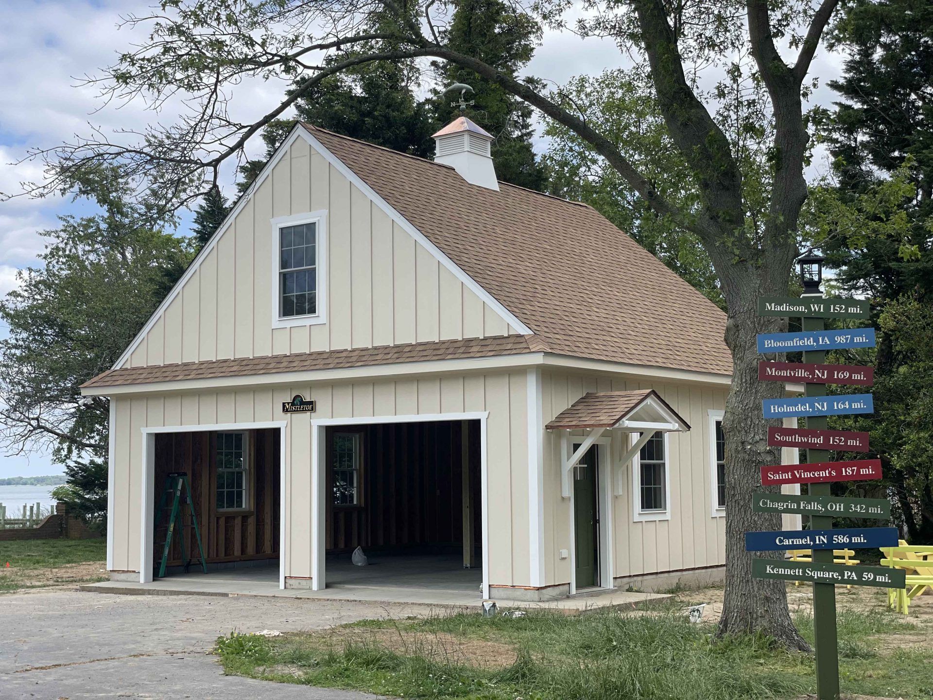 A white house with a brown roof and two garage doors