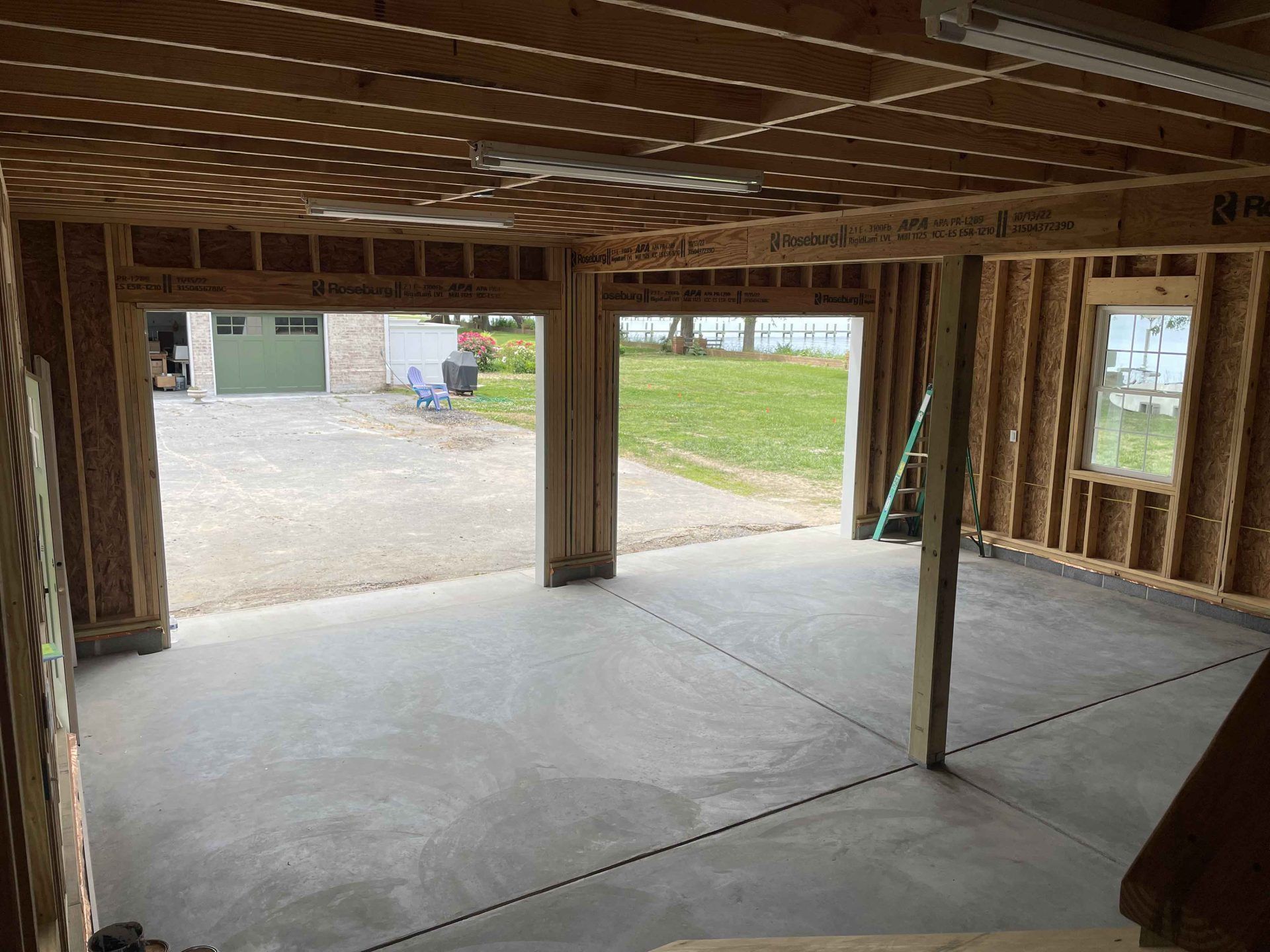 The inside of a garage under construction with the doors open.