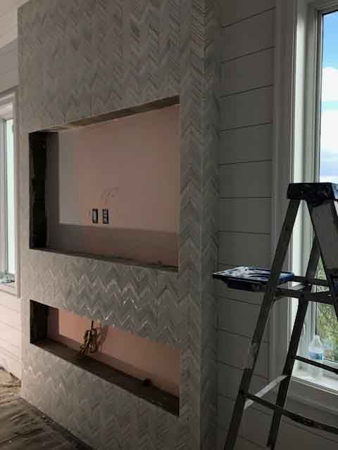 A ladder is sitting next to a fireplace in a living room.