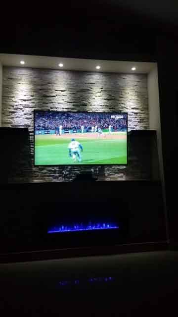 A flat screen tv is hanging on a wall in a living room.