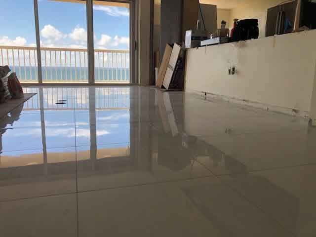 A living room with a sliding glass door and a view of the ocean.