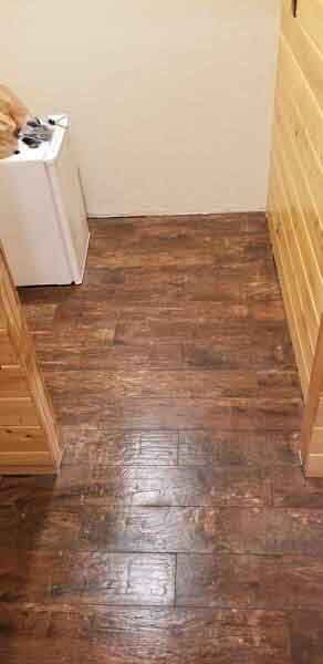 A laundry room with a wooden floor and a washer and dryer.