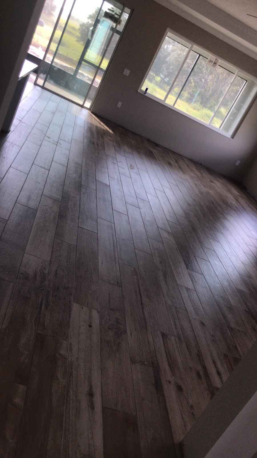 A living room with a wooden floor and a lot of windows.