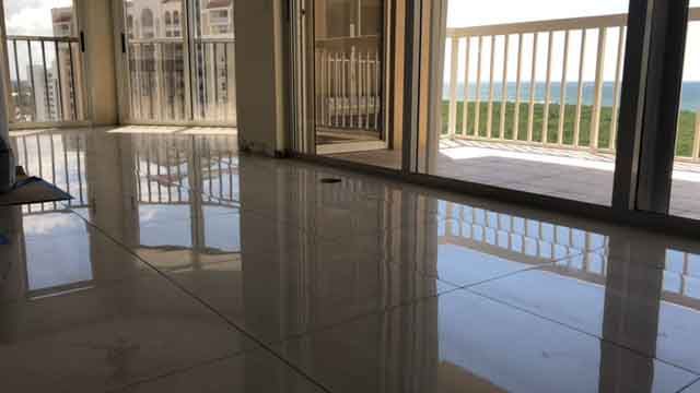 A large empty room with a balcony and a view of the ocean.