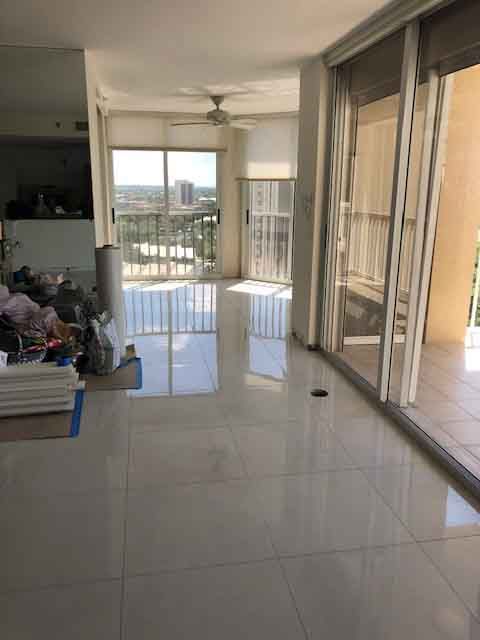 An empty living room with sliding glass doors and a balcony.