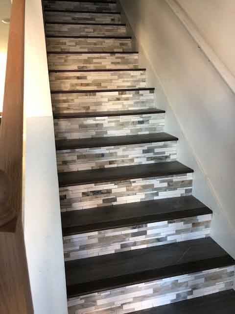 A set of stairs with a brick wall behind them.