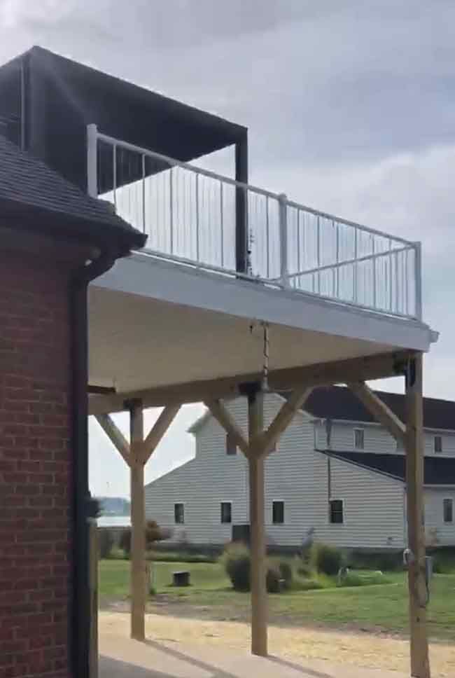 A large deck with a railing is sitting on top of a brick building.